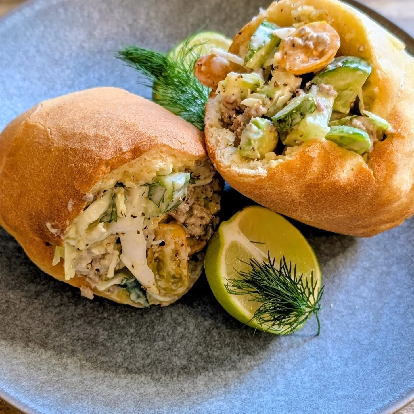 Soft homemade pita bread filled with seasoned beef mince and a fresh, crunchy salad of herbs,avocado, cucumber, iceberg lettuce, cabbage, and our own cherry tomatoes grown right in our backyard 🍅 &mdash; finished with a creamy sriracha mayonnaise fo