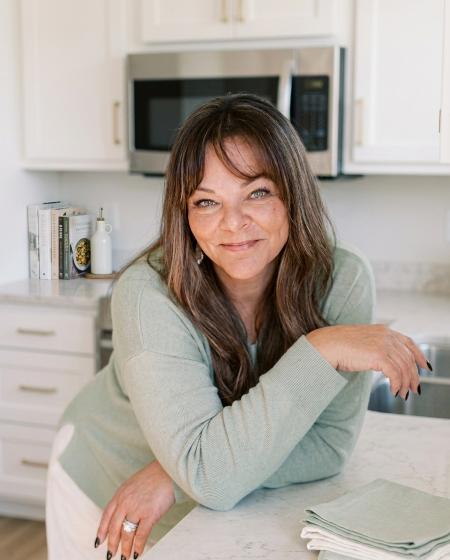 Chrystal Hood smiling and leaning on a kitchen counter