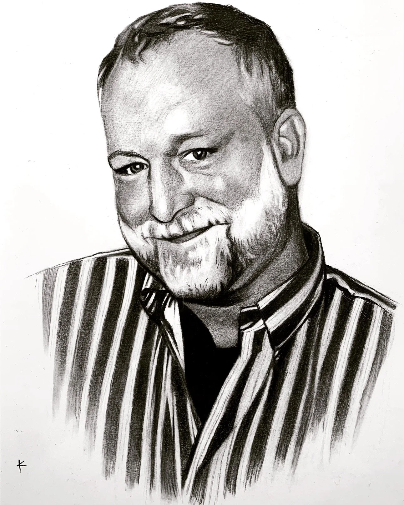 A black and white pencil sketch of a man with a beard, short hair, and a friendly smile, wearing a vertically striped shirt.
