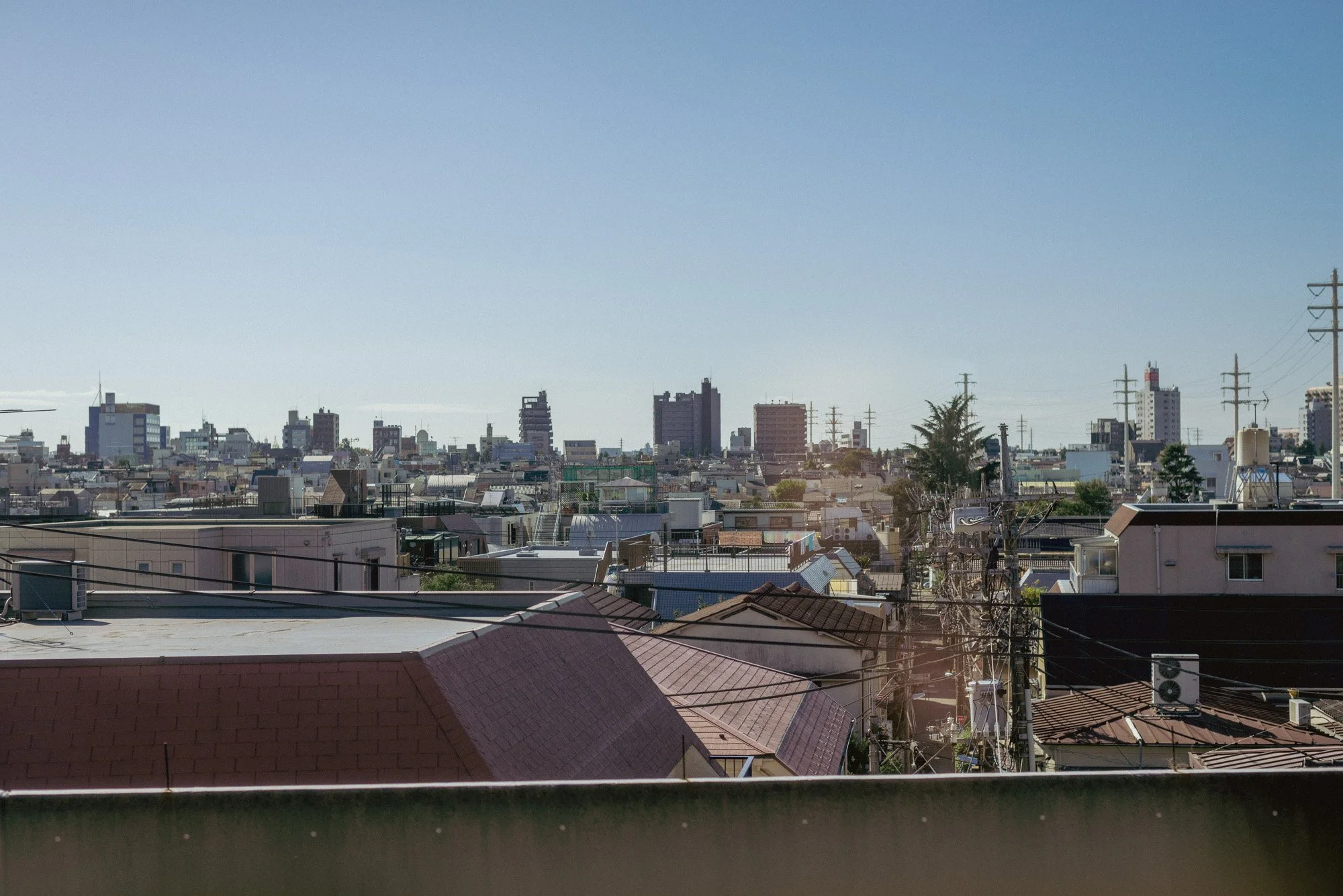 A view of building roofs, seen from a Tokyo train car