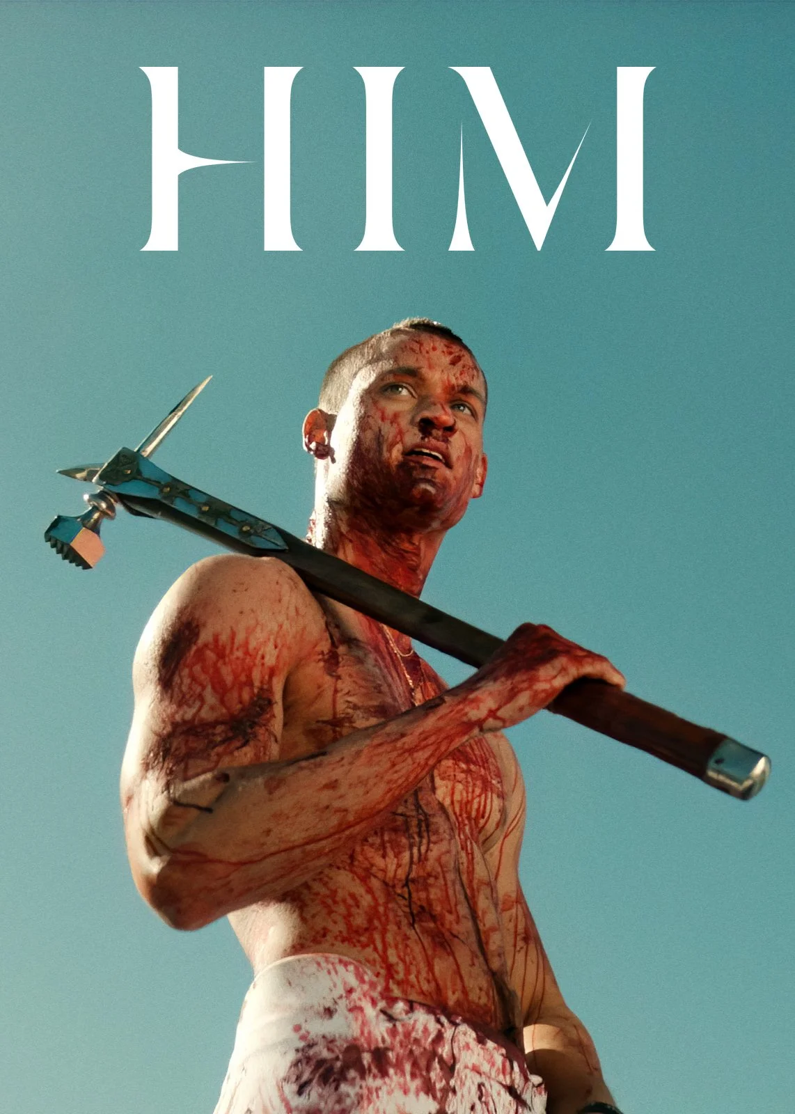 A shirtless man covered in blood holding a spear against a blue sky.