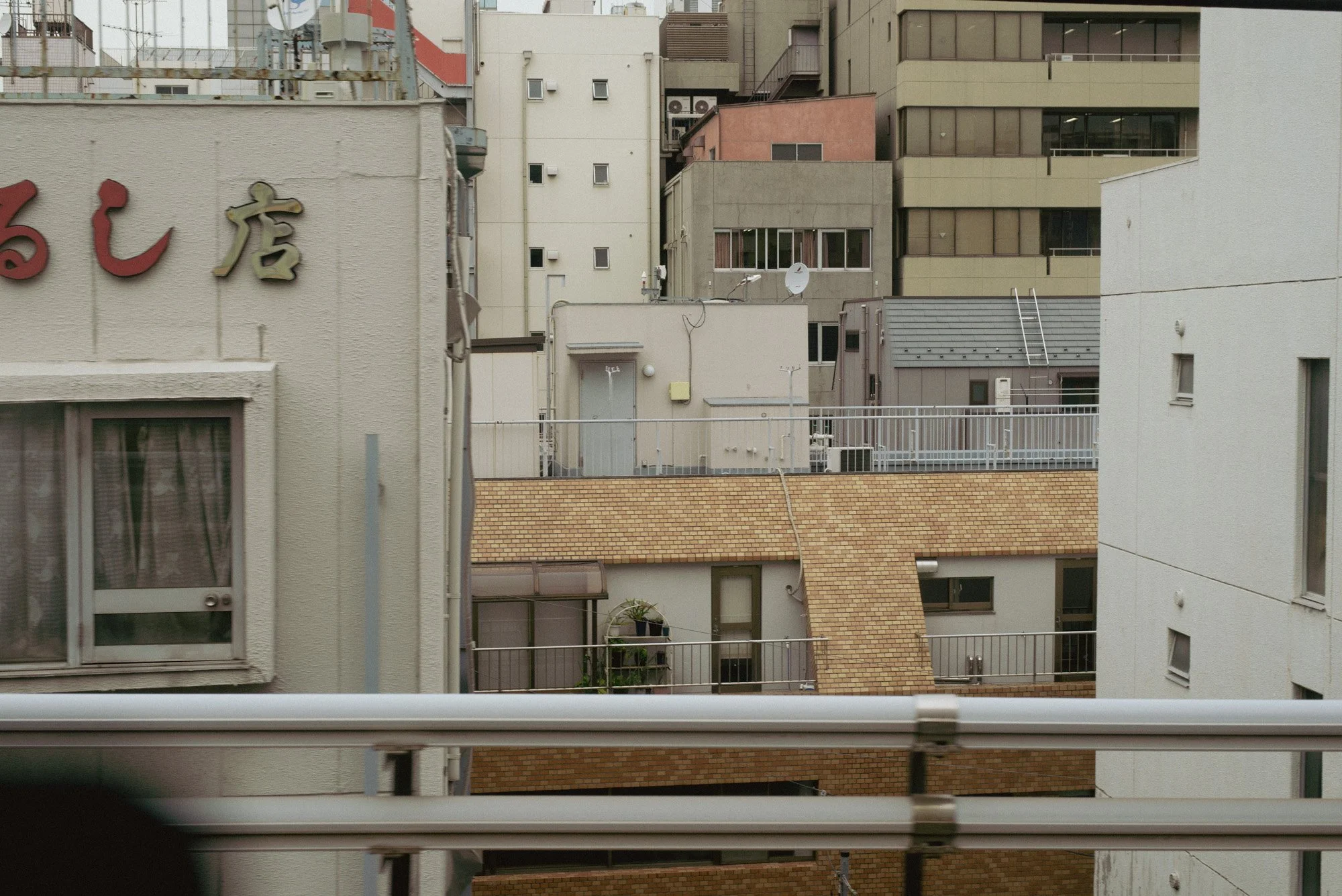 Layers of tall buildings seen from a Tokyo train window