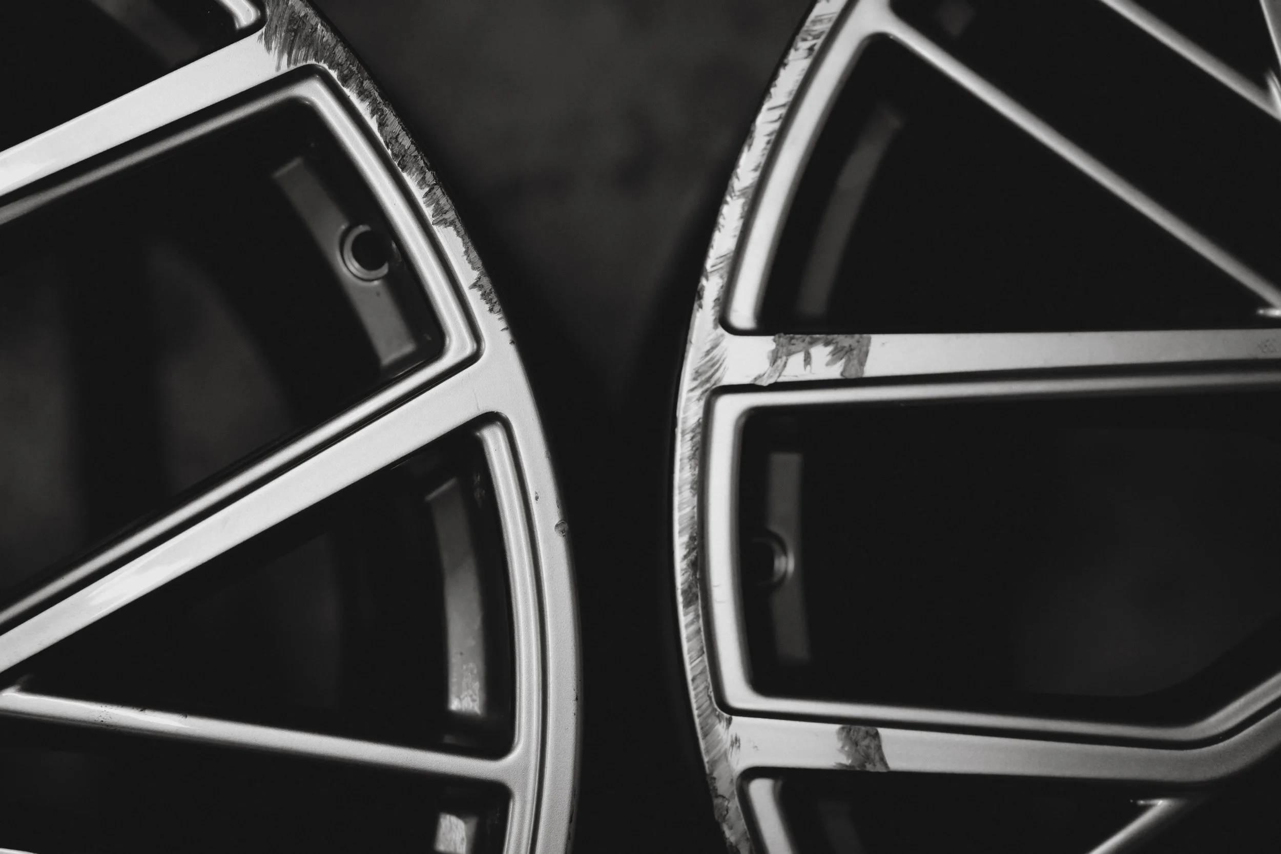 Nahaufnahme von beschädigten Automobilfelgen mit Kratzern und Absplitterungen am Rand