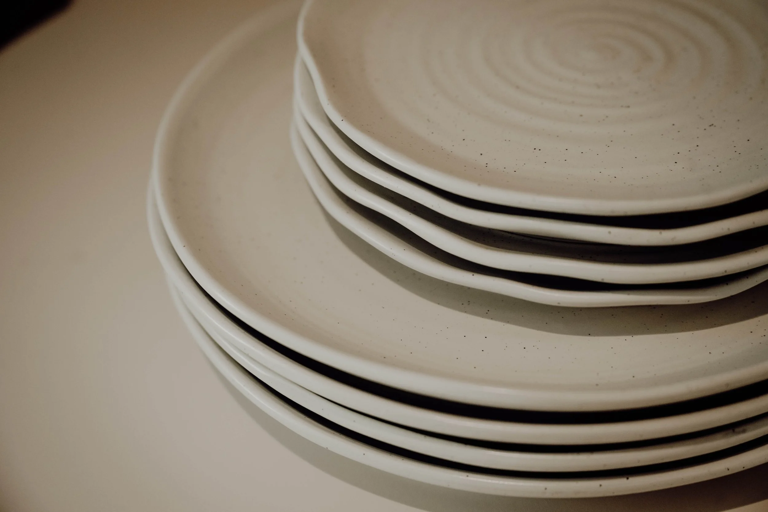 A stack of white speckled ceramic plates