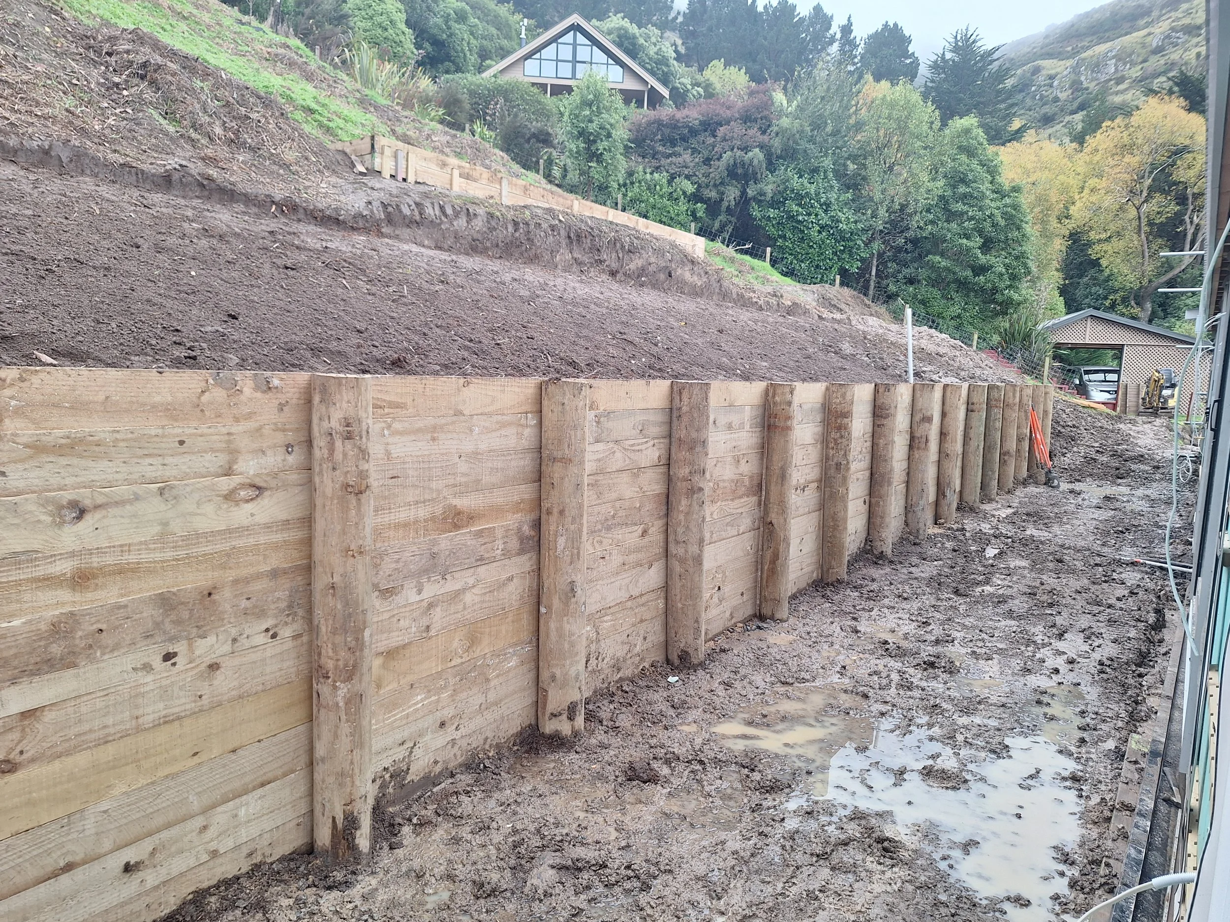 Tight access retaining wall behind house.