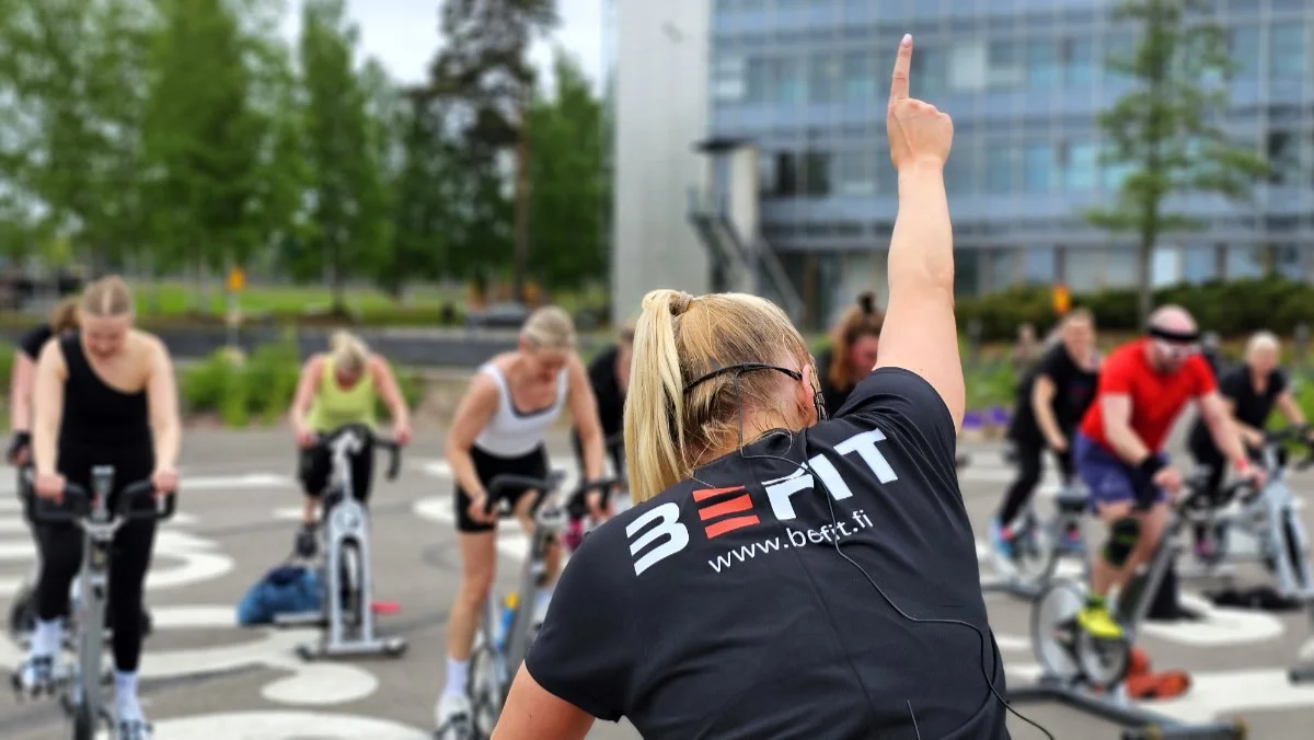 Yrityskiinteistön vuokralaisten henkilöstö osallistuu BeFitin organisoimalle spinning-tunnille Keilaniemen ARCin helipadilla BeFitin liikunnanohjaajan ohjauksessa
