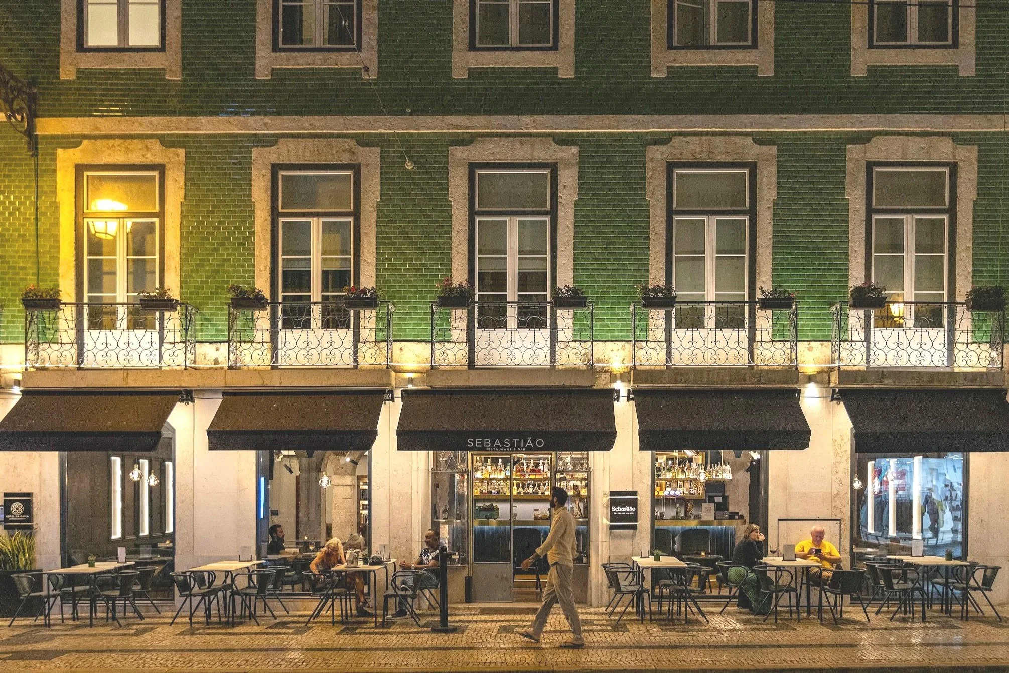 Lisbon building facade at night with man calmly walking
