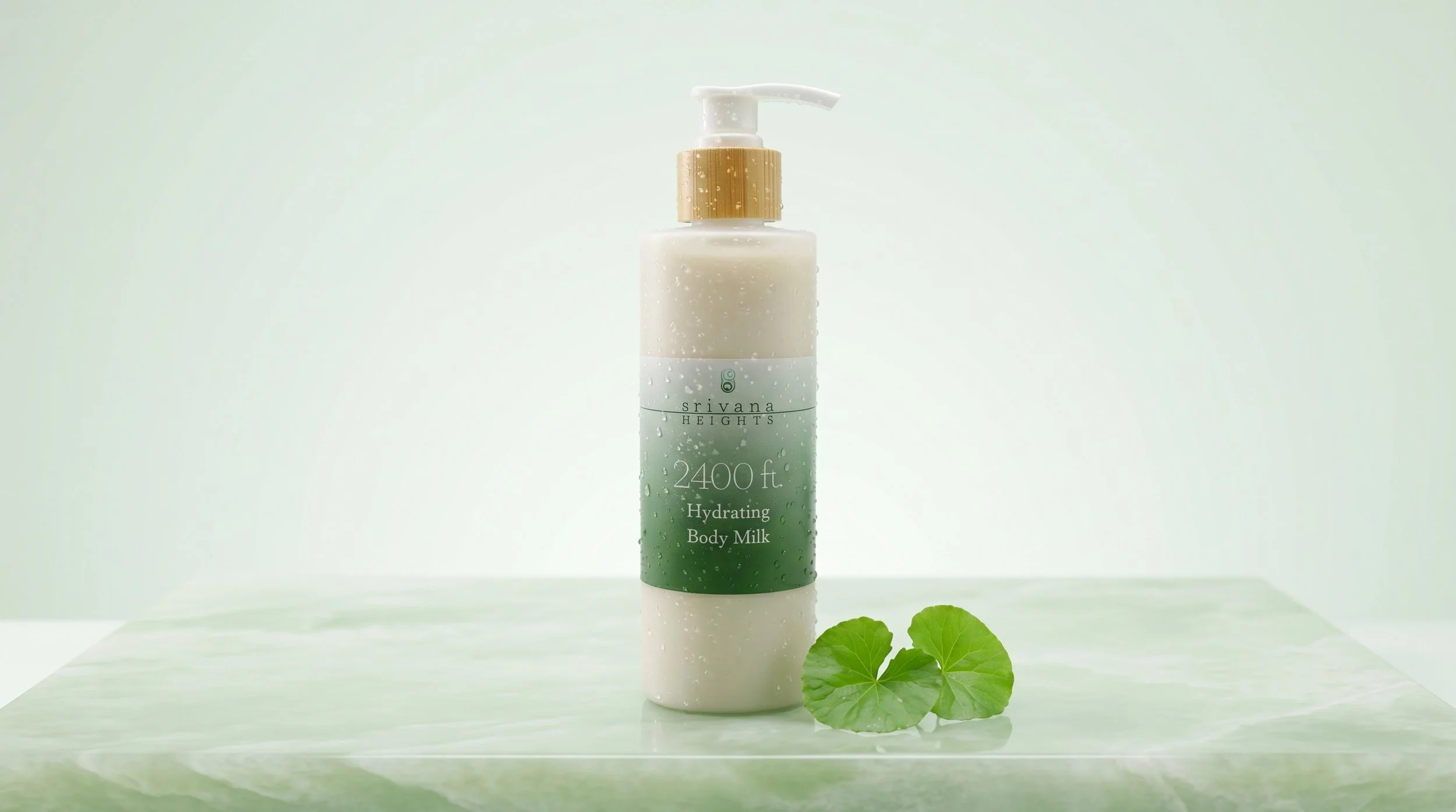 A bottle of hydrating body milk labeled 'Srivana Heights, 2400 ft.' with water droplets on it, placed on a surface with a green leafy plant in front of it and a light green background.