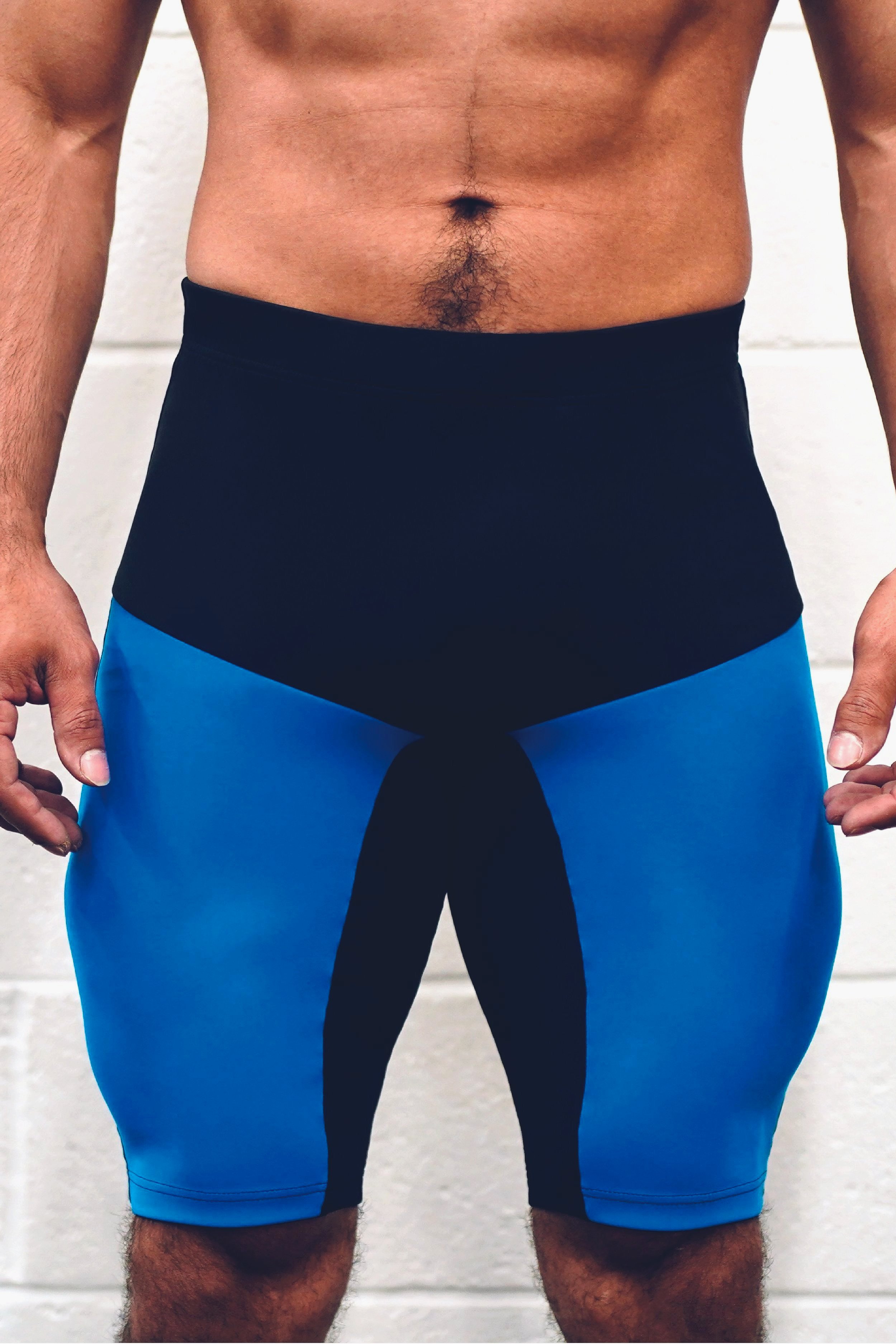Close-up of man's midsection wearing blue and black compression shorts.