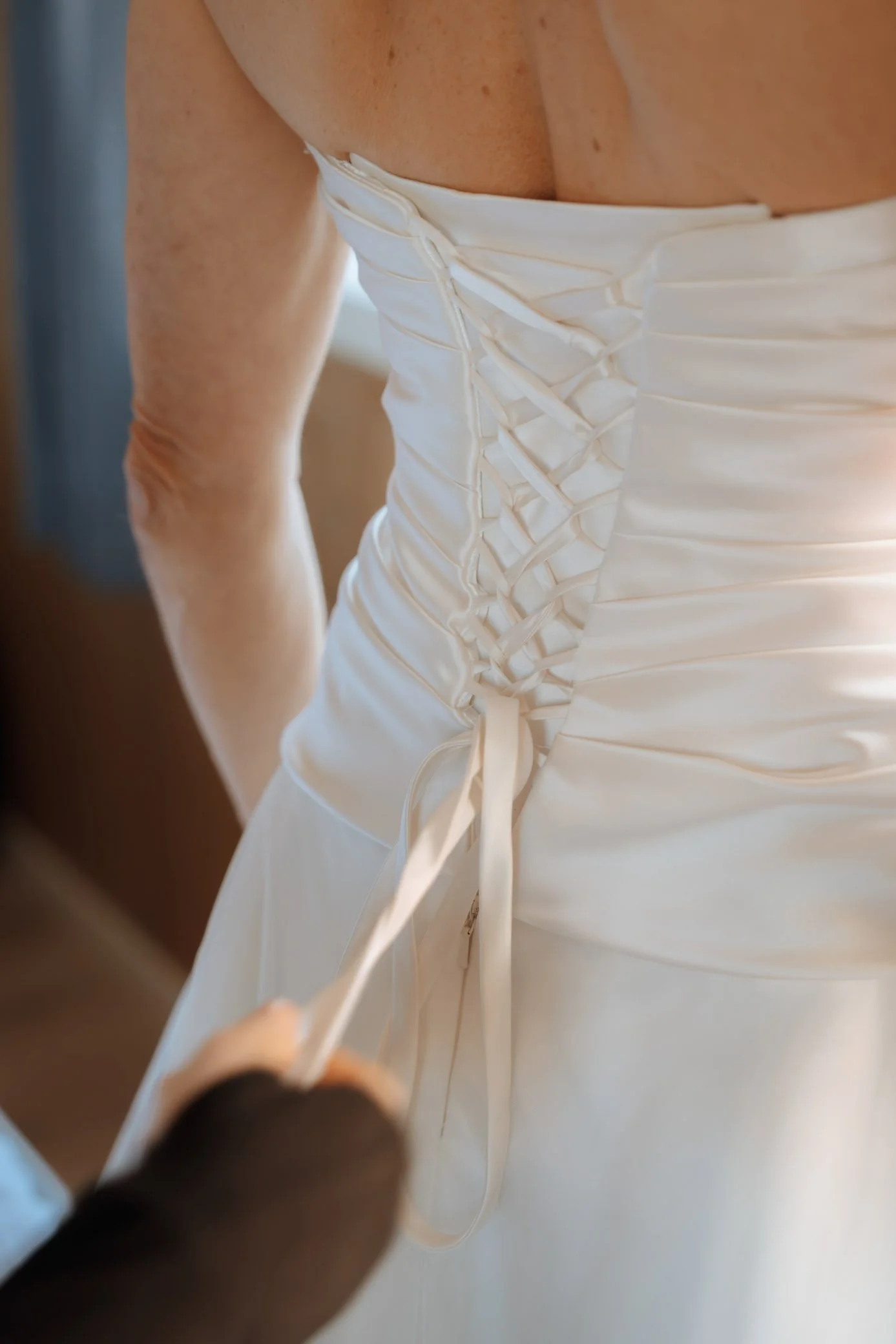Bride adjusting wedding dress during preparation in Lofoten