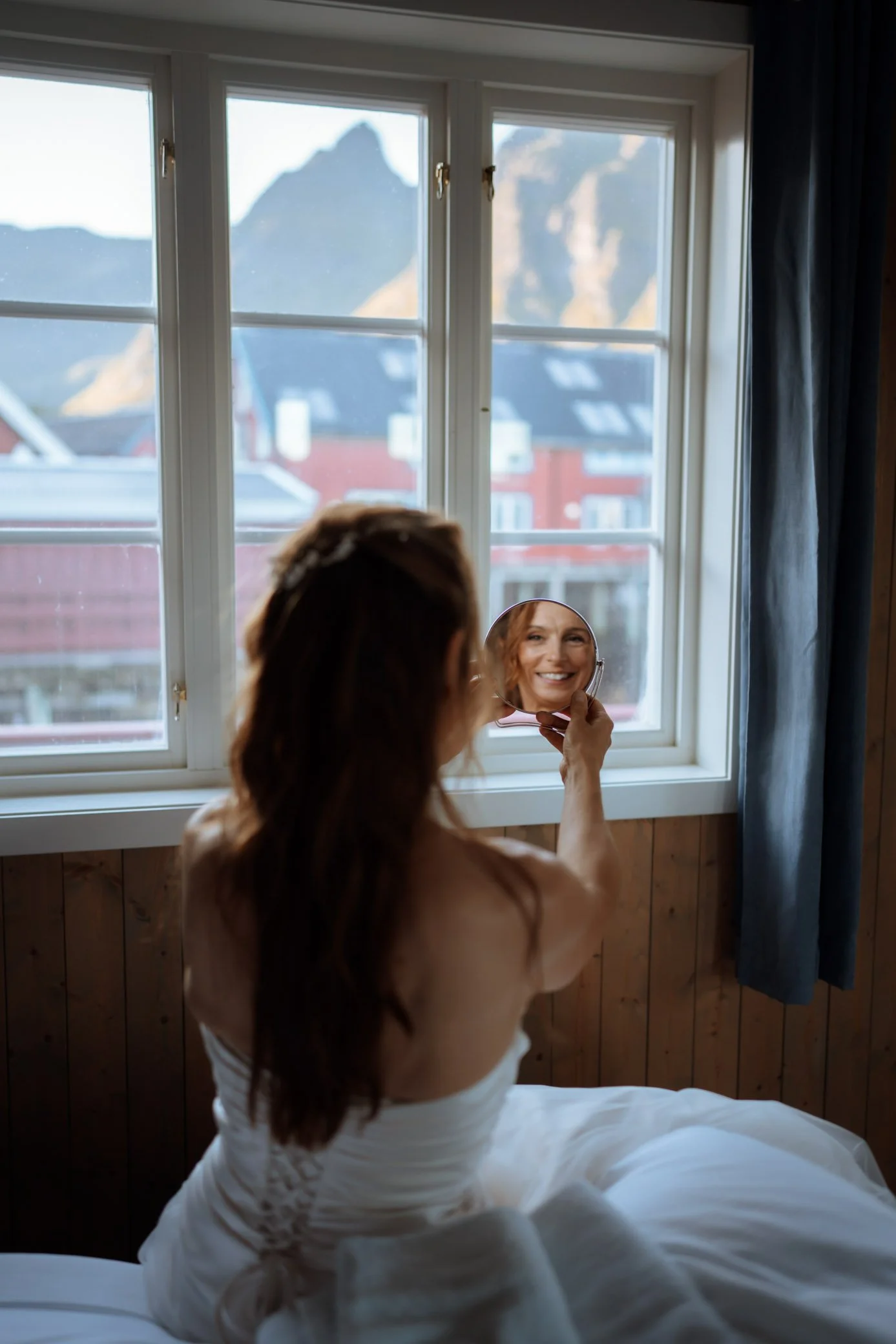 Bride getting ready in rorbuer cabin during Lofoten elopement