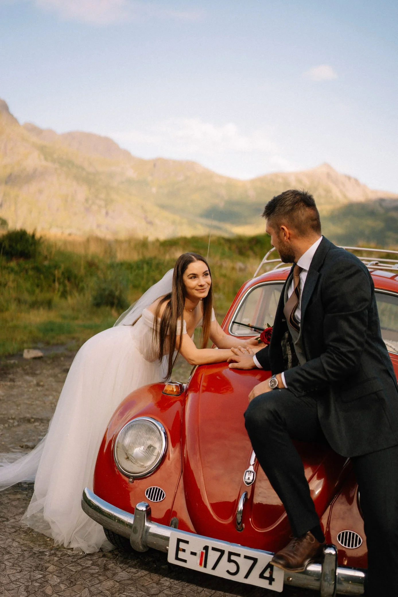 Couple standing by car with mountains in Lofoten during elopement 