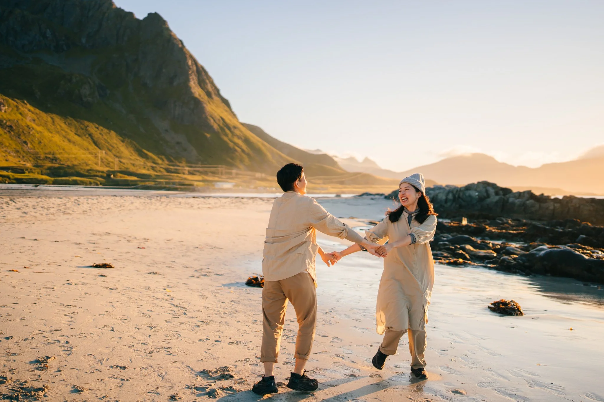 Couple having fun on a arctic beach during couple photoshoot in Lofoten