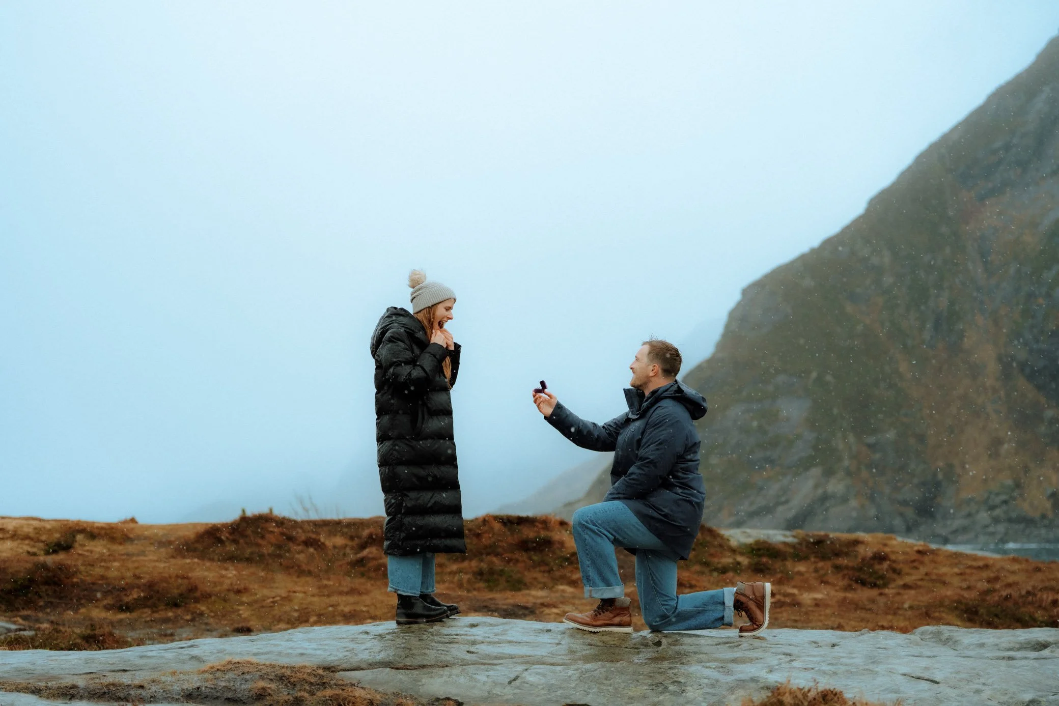 Michael proposing to Alita during surprise proposal in Å i Lofoten in the rain
