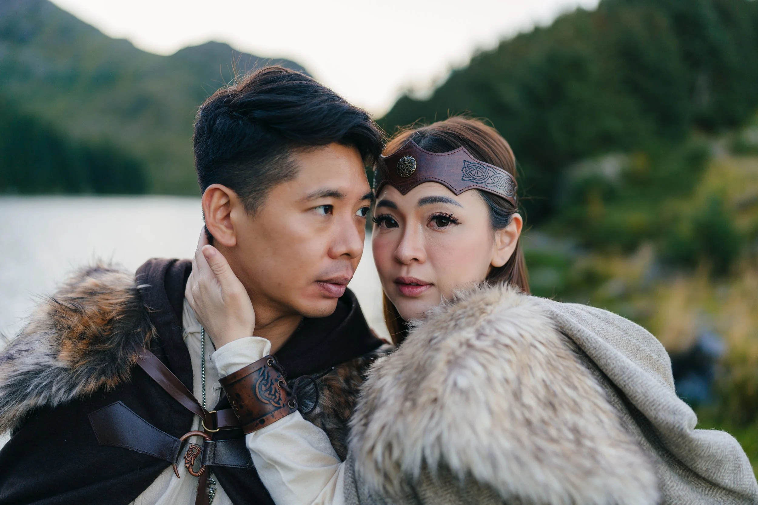 Viking photoshoot in Lofoten, Norway — couple in authentic Viking costumes with shield and sword in a dramatic Nordic landscape.