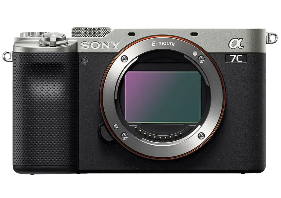 Digital camera with a black and silver body, autofocus lens mount, and a textured grip on the left side.