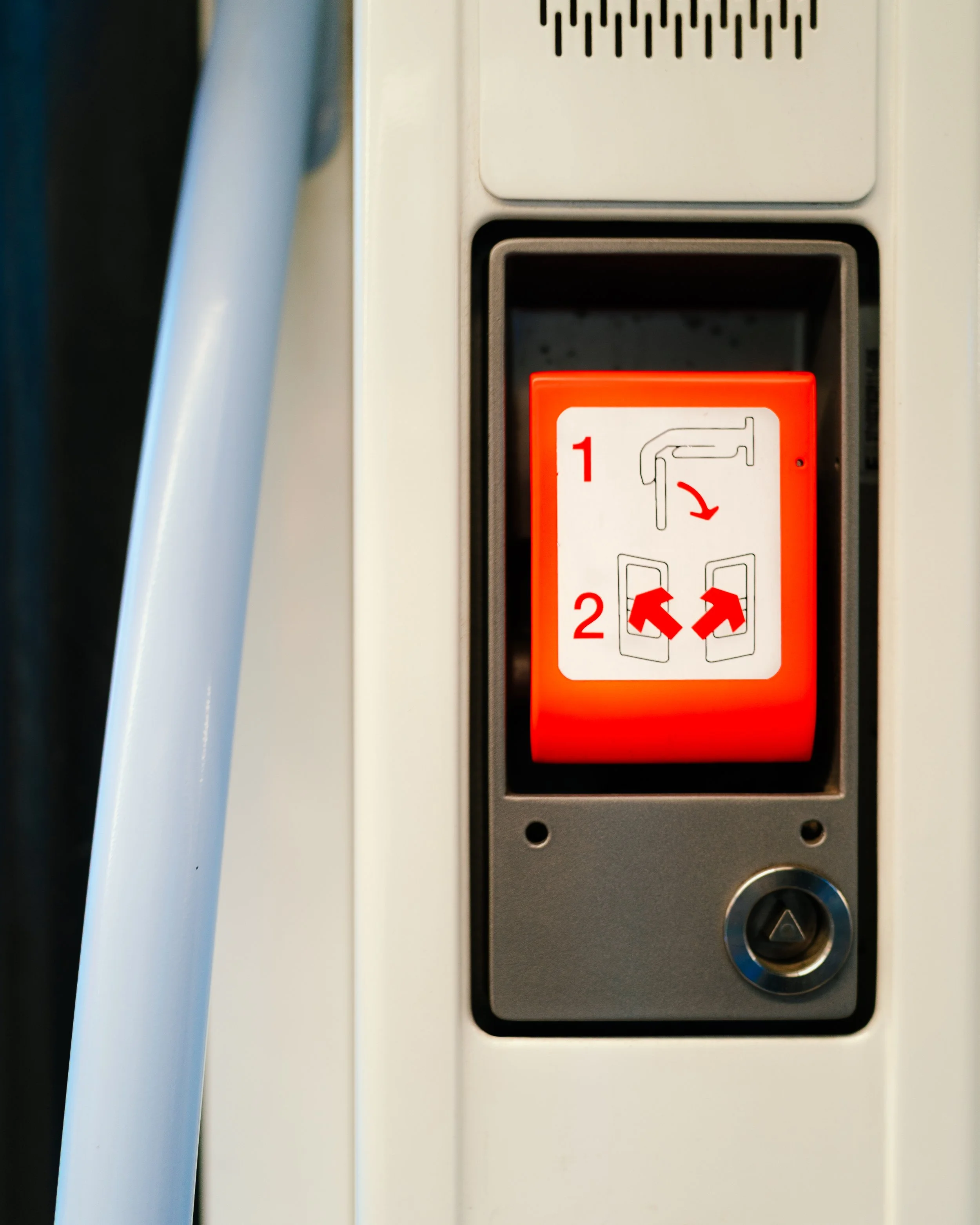 Close-up of a machine's instruction panel with red and white labels, showing step-by-step assembly or operation instructions, including arrows and numbered steps.