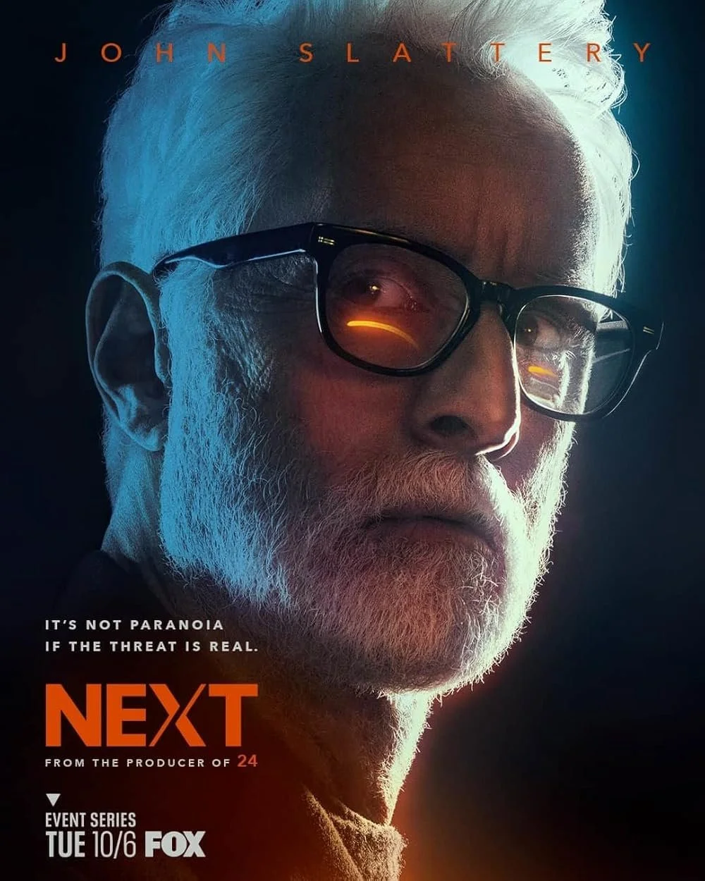 Promotional poster for the TV series 'Next', featuring a close-up of an older man with white hair, a beard, glasses, and reflected lights in his glasses. The text highlights the series premiere on Fox, with a tagline, 'It's not paranoia if the threat