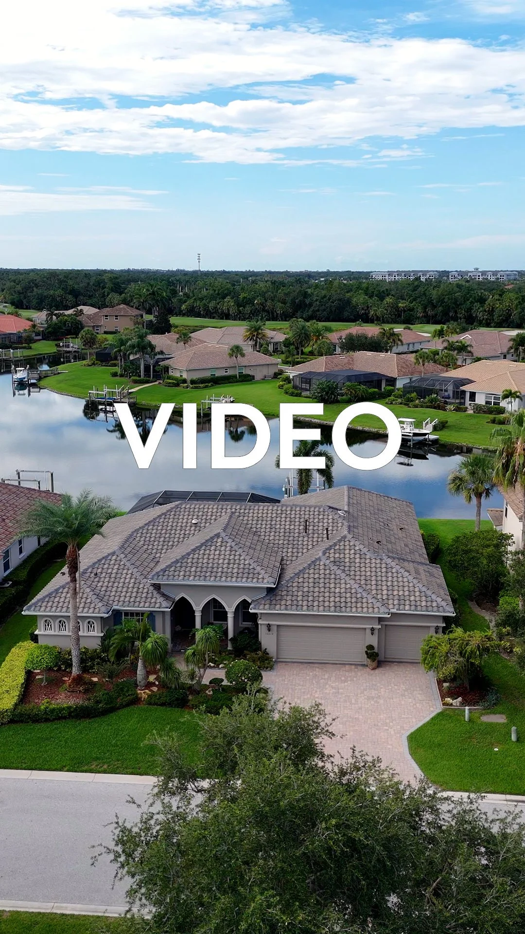 Aerial view of a suburban neighborhood with houses, a canal, and lush greenery under a partly cloudy sky, with the word 'VIDEO' overlaid.