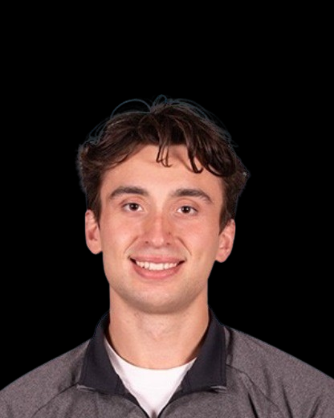 Portrait of a young man with brown hair, smiling, wearing a gray jacket, against a black background.