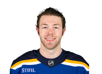 Headshot of a young man in a St. Louis Blues hockey jersey smiling at the camera.