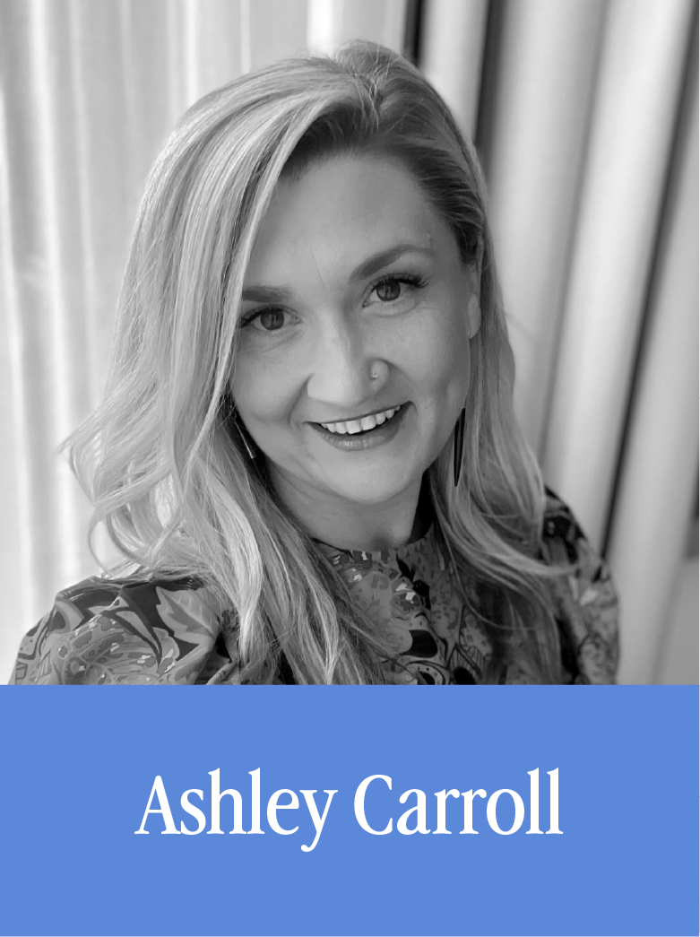 Black and white photo of a woman with long, wavy hair smiling, wearing a patterned top, with the name 'Ashley Carroll' written on a blue background at the bottom.