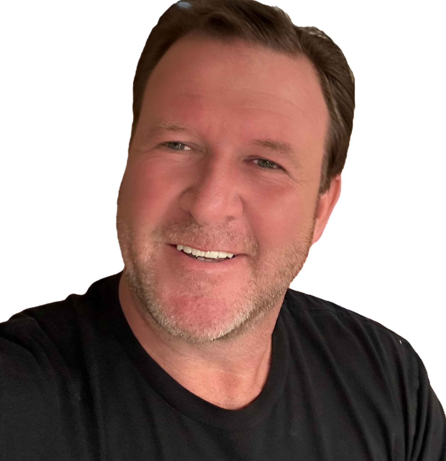 Close-up of a smiling man with short brown hair, light stubble, wearing a black shirt, looking at the camera.