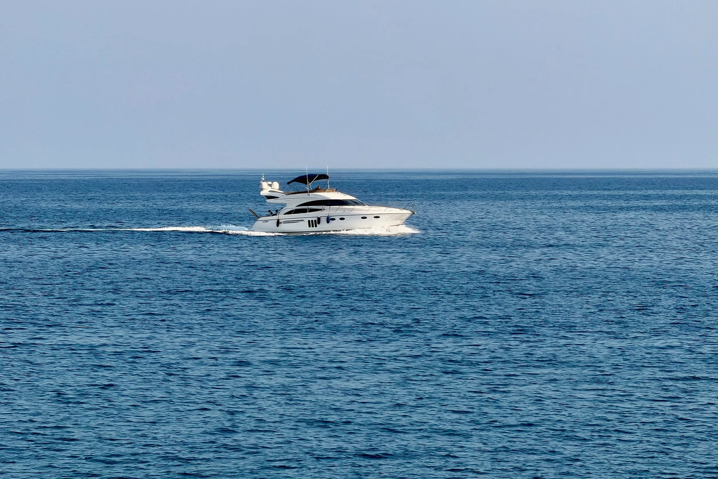 White motor yacht crossing deep blue open sea