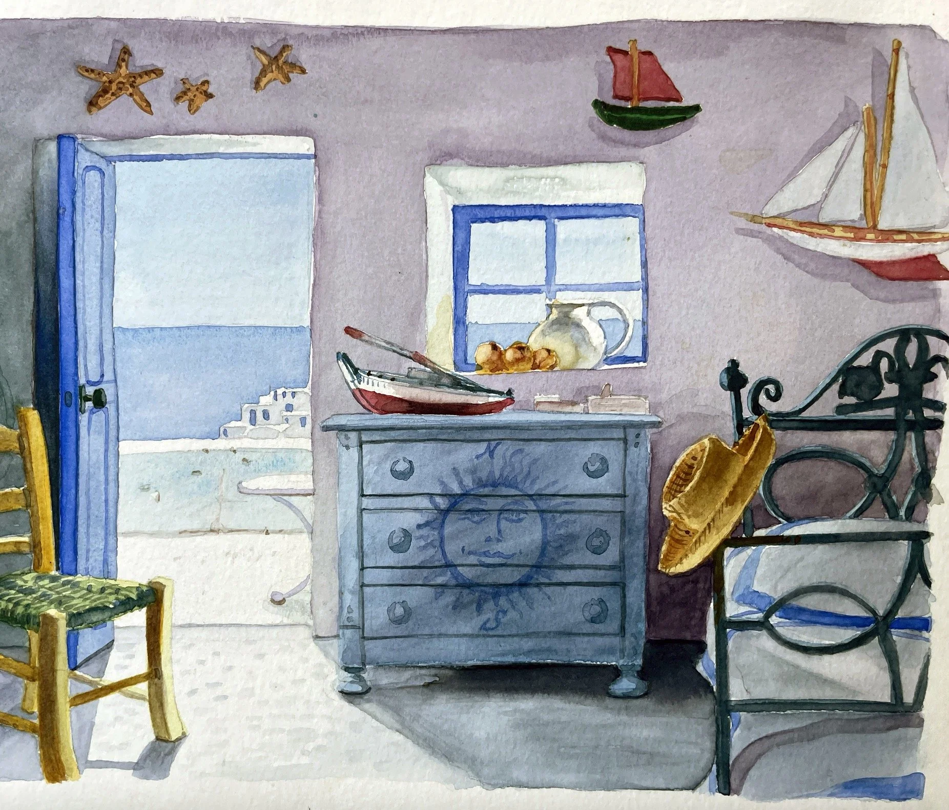 Une scène de cuisine avec une fenêtre, un tiroir gris, un meuble avec un soleil peint, un plateau avec des fruits, deux voiliers sur le mur, et des chaises, dont une en bois avec un coussin vert.