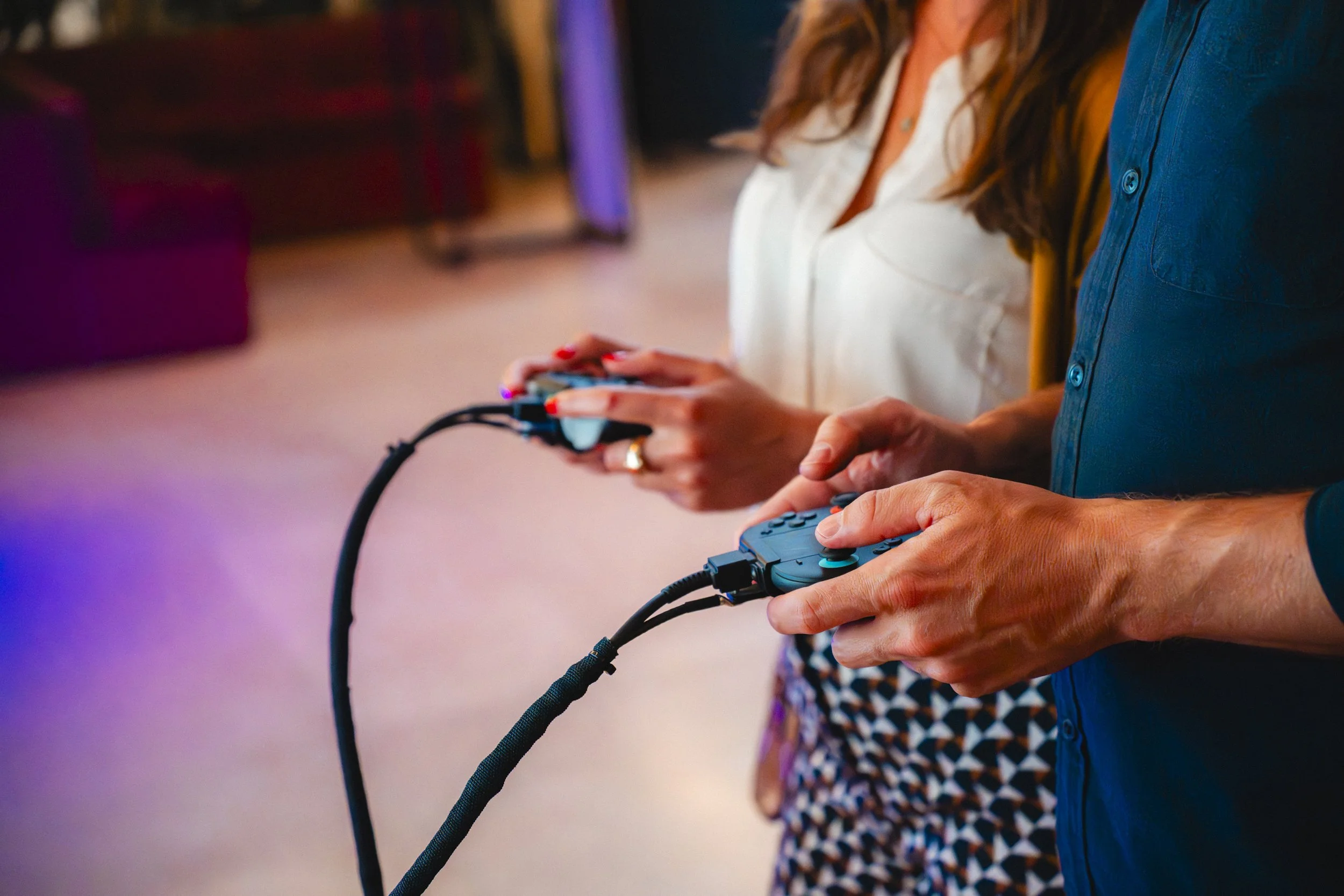 People holding arcade controllers, playing a video game at an arcade or gaming event.
