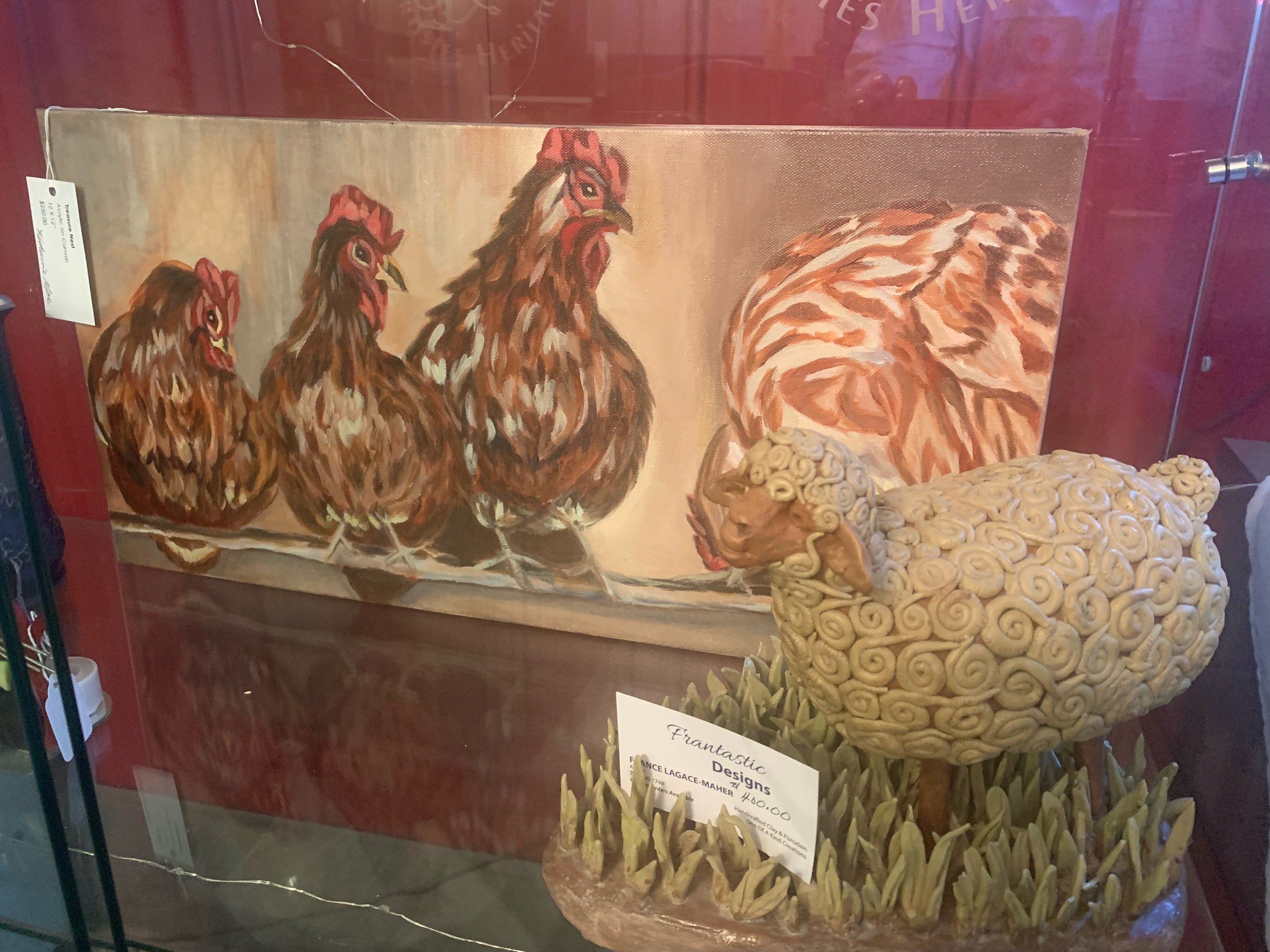 A painting of four chickens and a ceramic sculpture of a sheep with curly wool, set against a red background with grass.