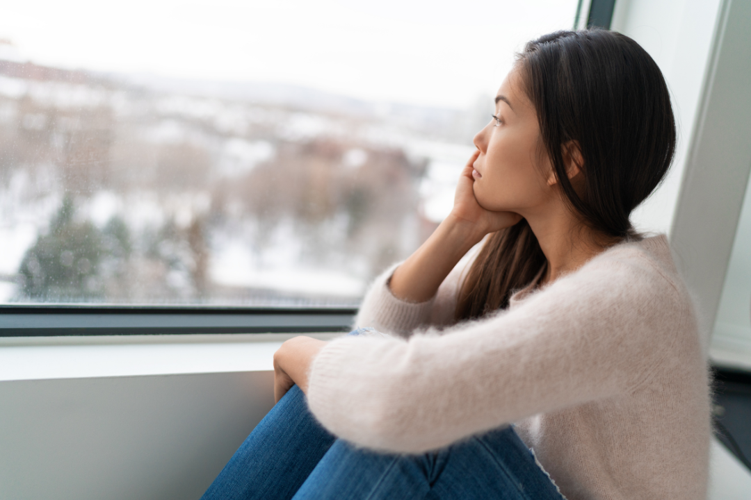 woman depressed looking out of window