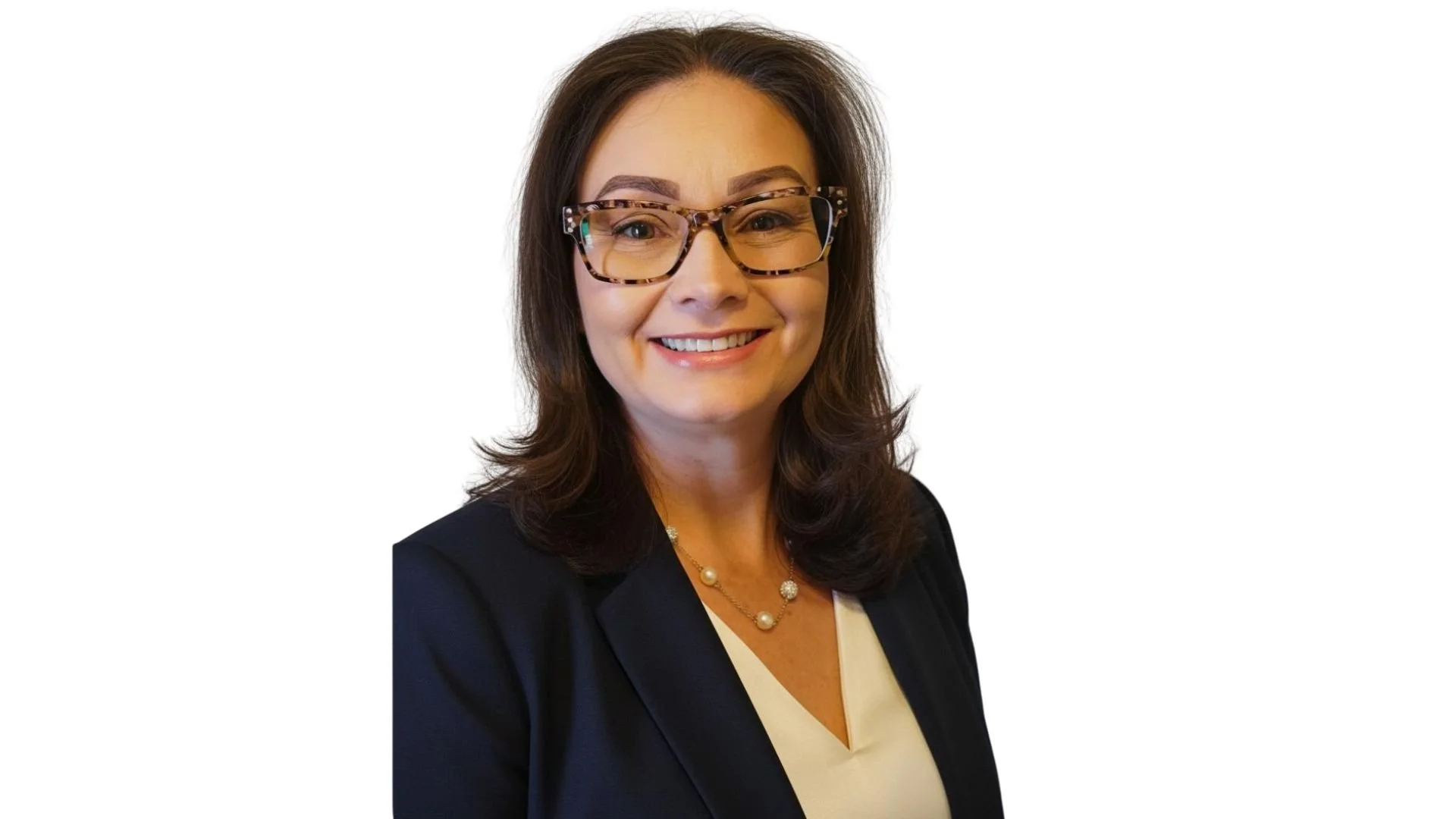 Professional woman with shoulder-length dark hair, glasses with a tortoise shell pattern, smiling, wearing a dark blazer, a light-colored blouse, and a pearl necklace.