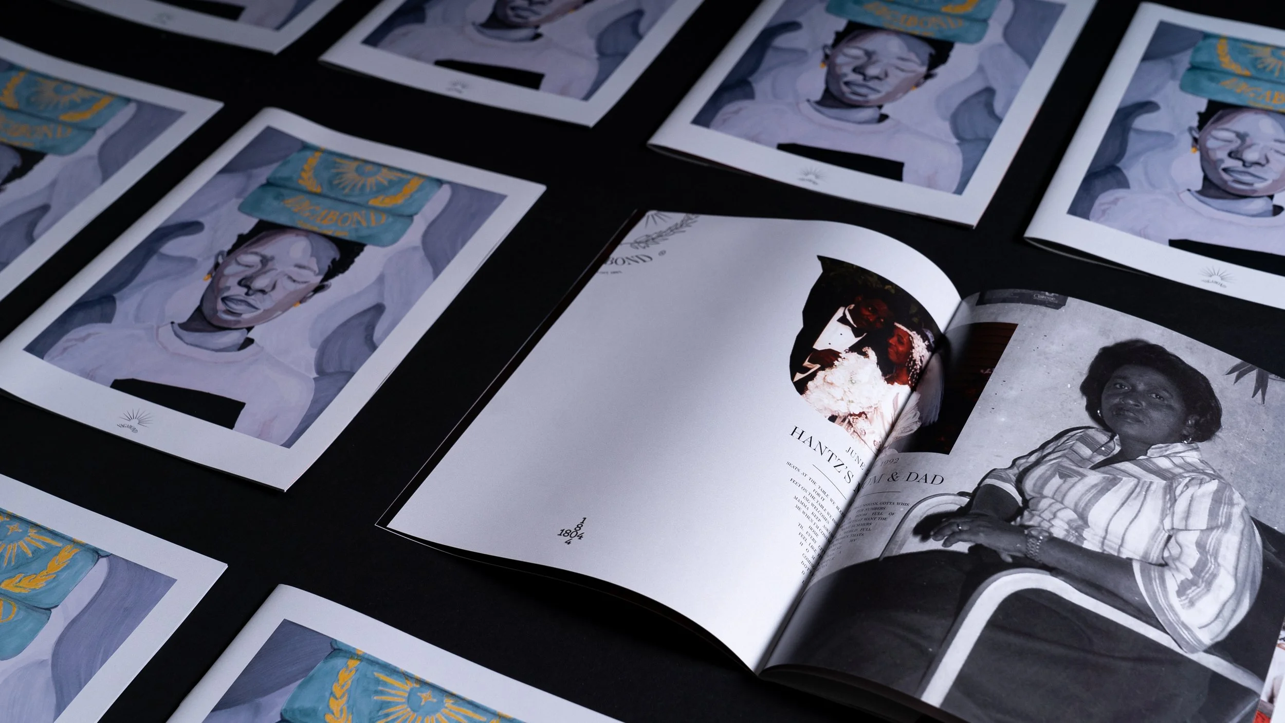 Colorful portraits of a woman with a banner reading 'Malibongwe' printed on her head, displayed on printouts and an open magazine page showing black-and-white photos of the same woman.