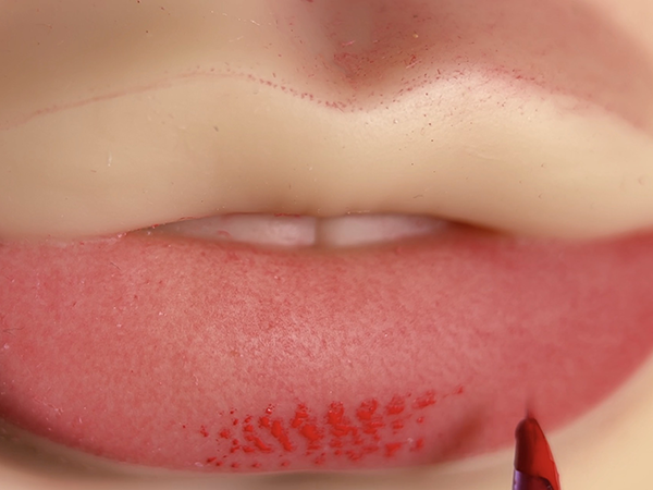 Lip blush practice on fake skin showing gradual color build-up and controlled pigment layering.