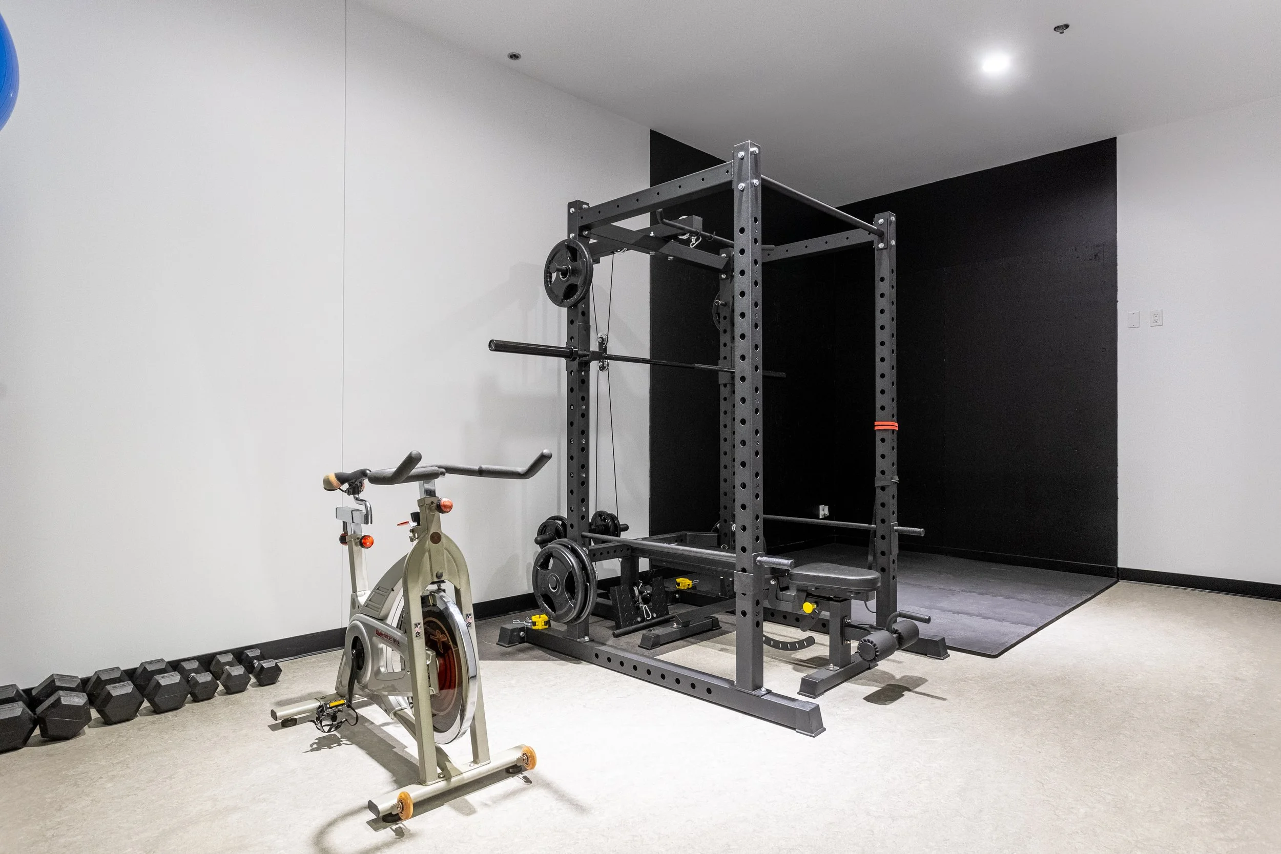 Salle de sport avec un vélo d'exercice et une station d'entraînement de musculation.