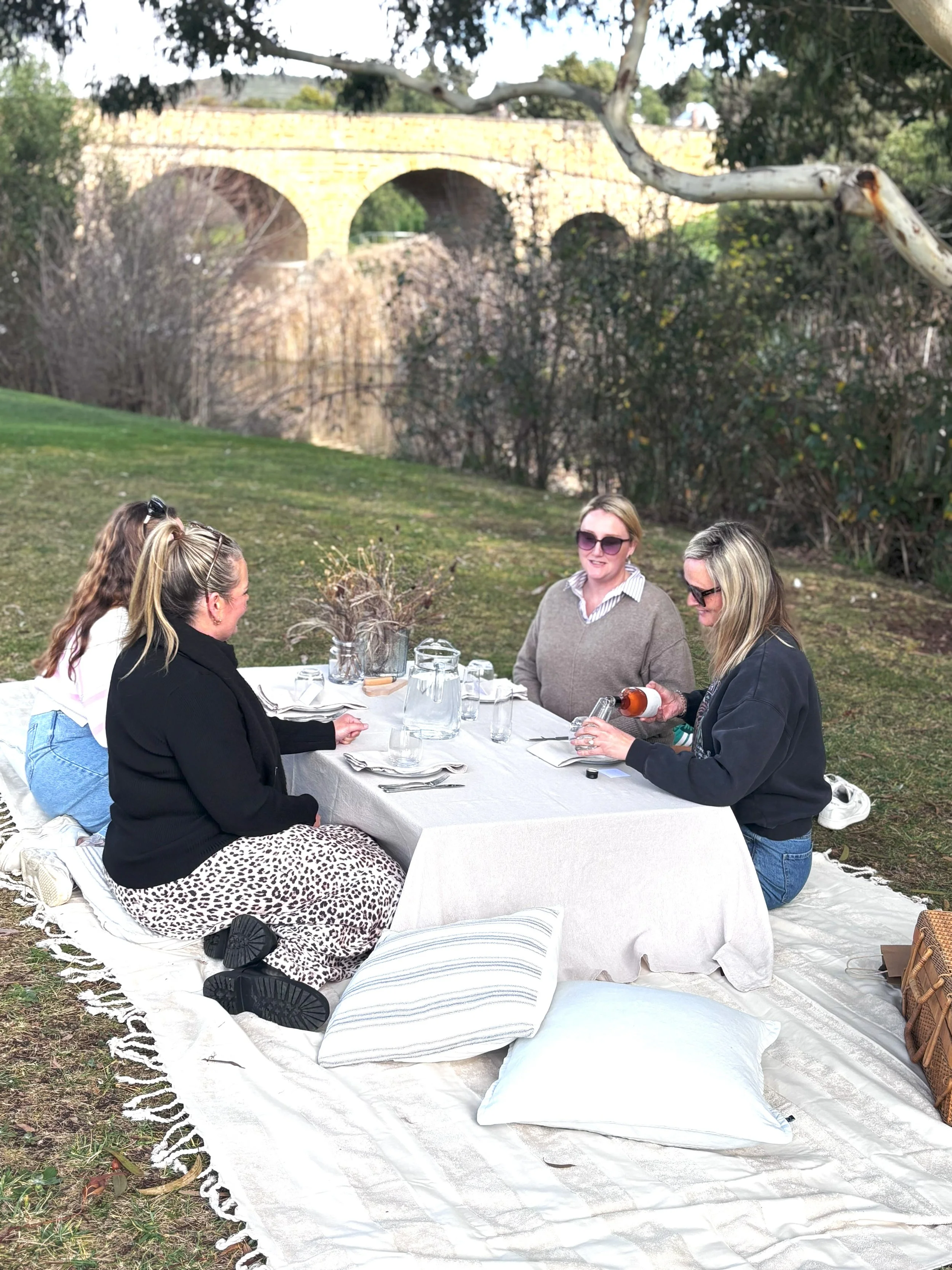 4 ladies having a picnic by the Richmond Bridge in Richmond, Tasmania