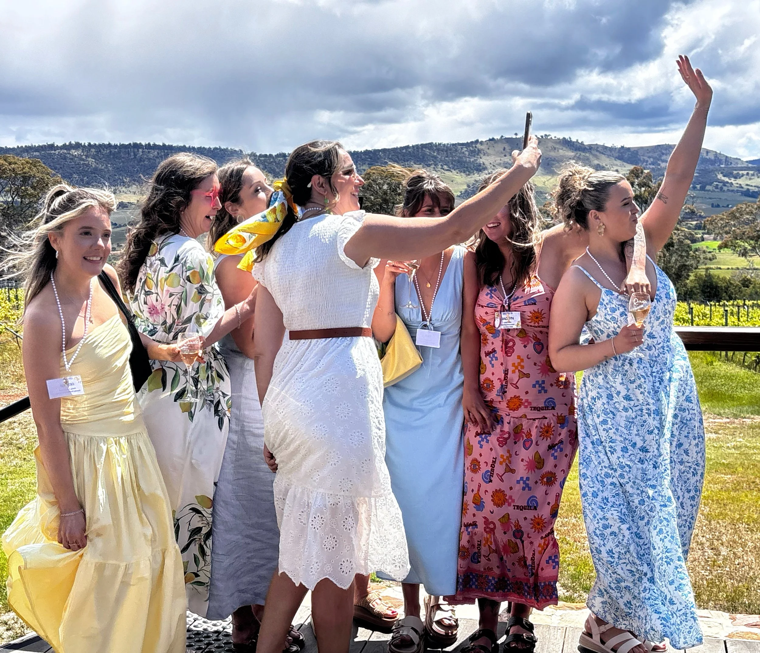 Group of women taking a selfie on the balcony at a vineyard in the sun.