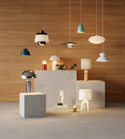 Display of various modern pendant, table, and floor lamps on concrete pedestals against a wooden wall.