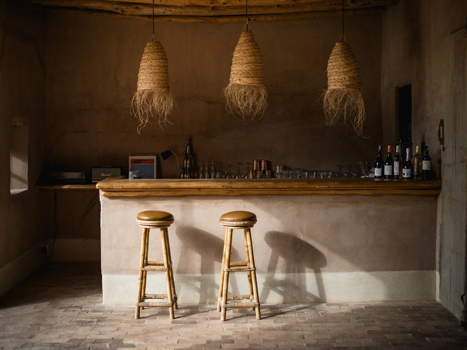 Bar interior at Berber Lodge near Marrakech, understated space with natural materials and warm sunset light