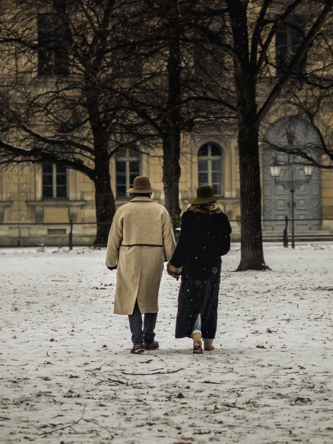 A couple walking on a snowy winter day in the Hofgarten, Munich, Germany