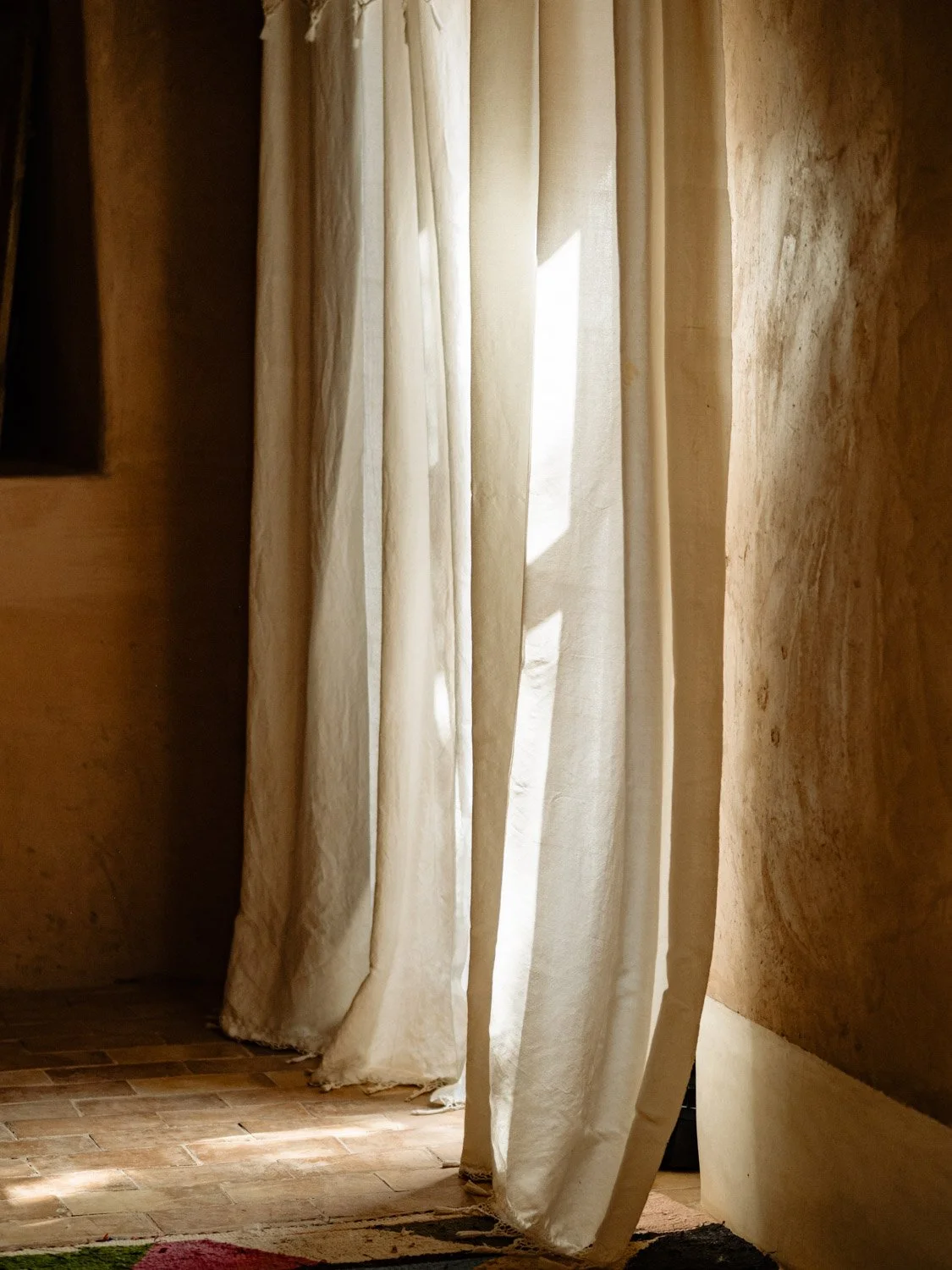 Light-filled suite at Berber Lodge near Marrakech, sunlight patterns on cotton curtains