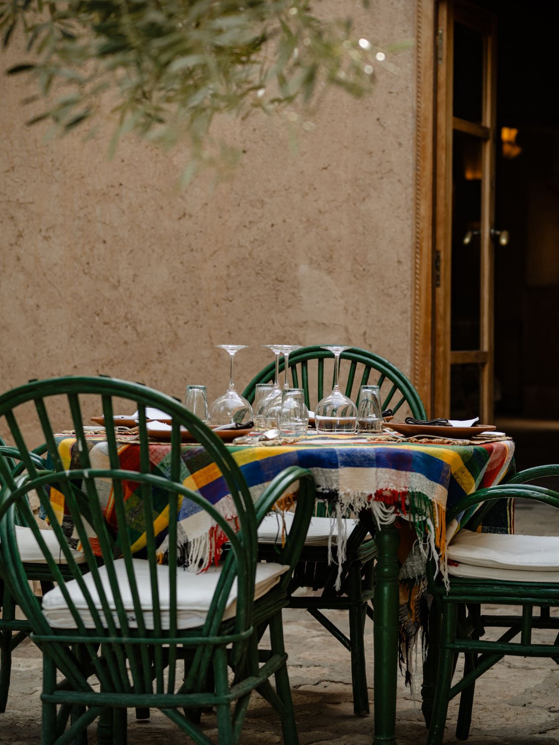 Courtyard table at Berber Lodge near Marrakech, dinner setting with plates, glassware, and soft linen tablecloth