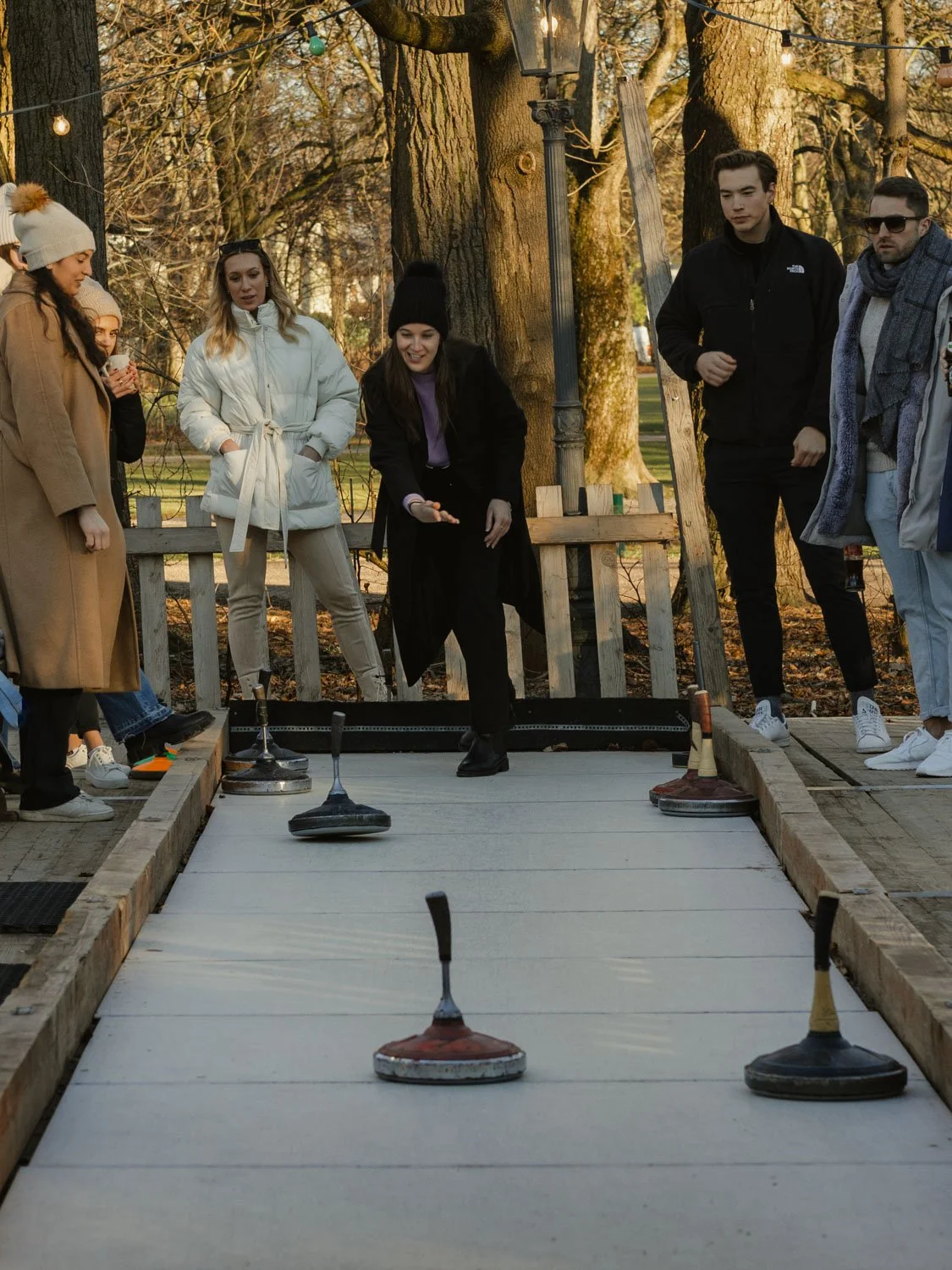 Group of friends playing Bavarian curling in Luitpoldpark , Munich, Germany