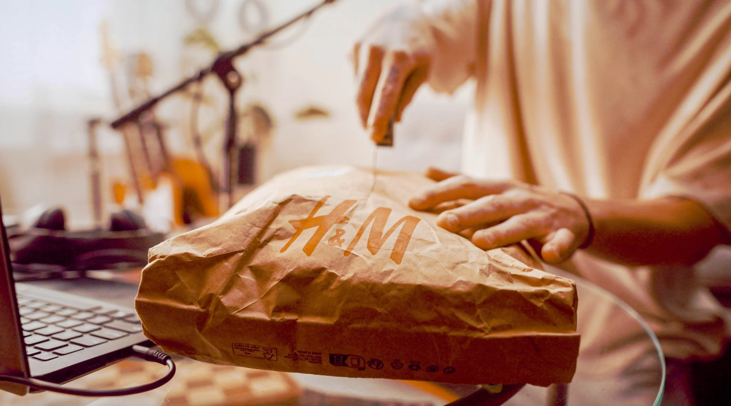 Person reaching into a refrigerator door, holding a box of colorful canned beverages labeled 'Two Robbers,' with lemons, limes, oranges, and a jar of pickles visible inside the fridge.