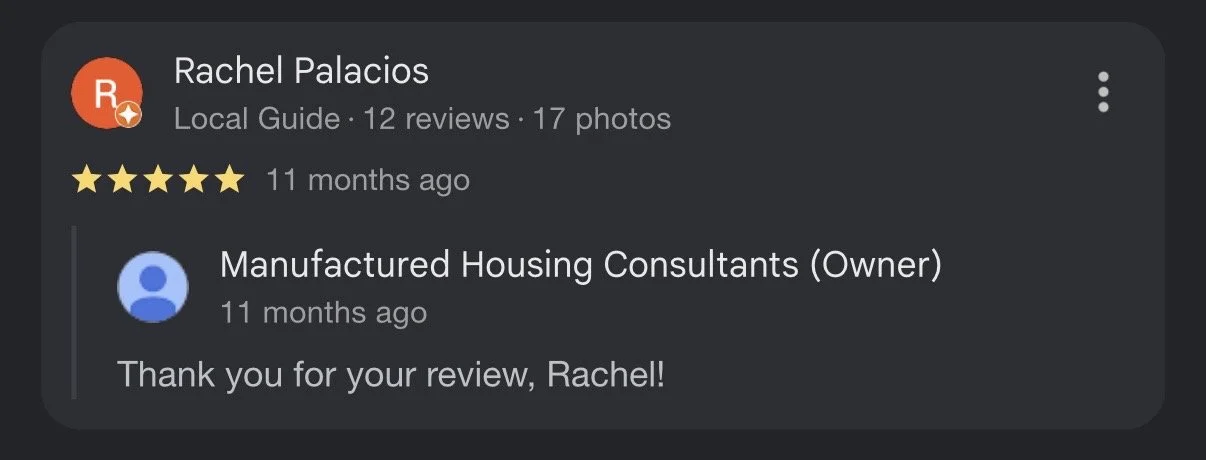 Modern house with wooden panel exterior in a mountainous landscape with yellowish-green vegetation and a cloudy sky in the background.