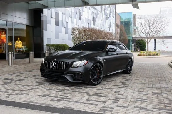 Black Mercedes-Benz luxury sedan parked outside modern building