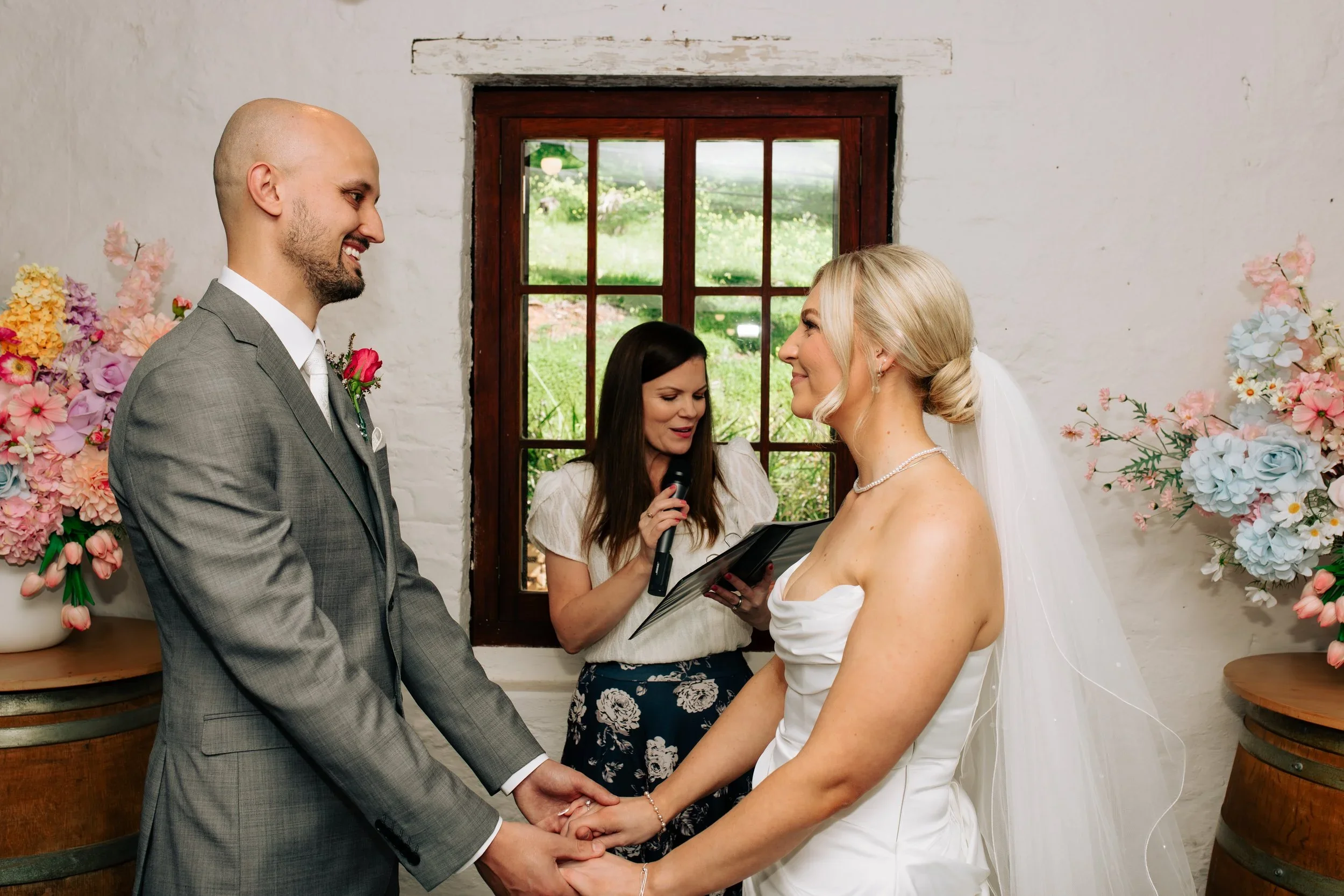 Niamh reading the ceremony with a microphone as the couple smile at each other