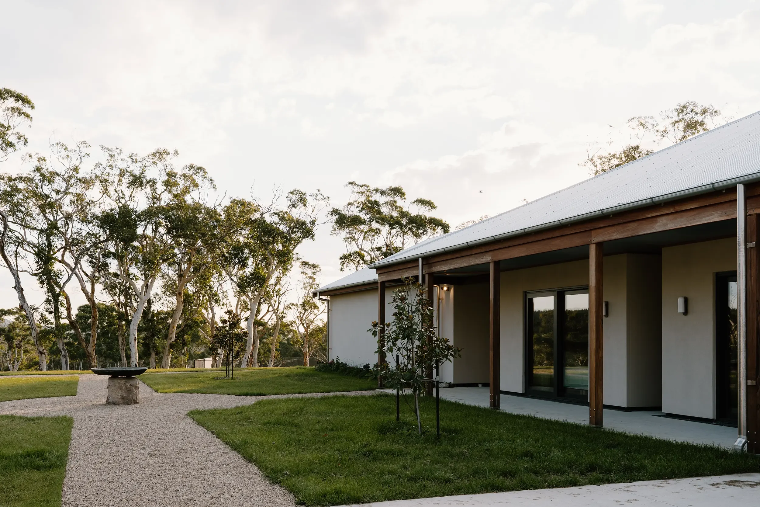 exterior of the house showcasing entrace and walkway that features a birdbath in the centre
