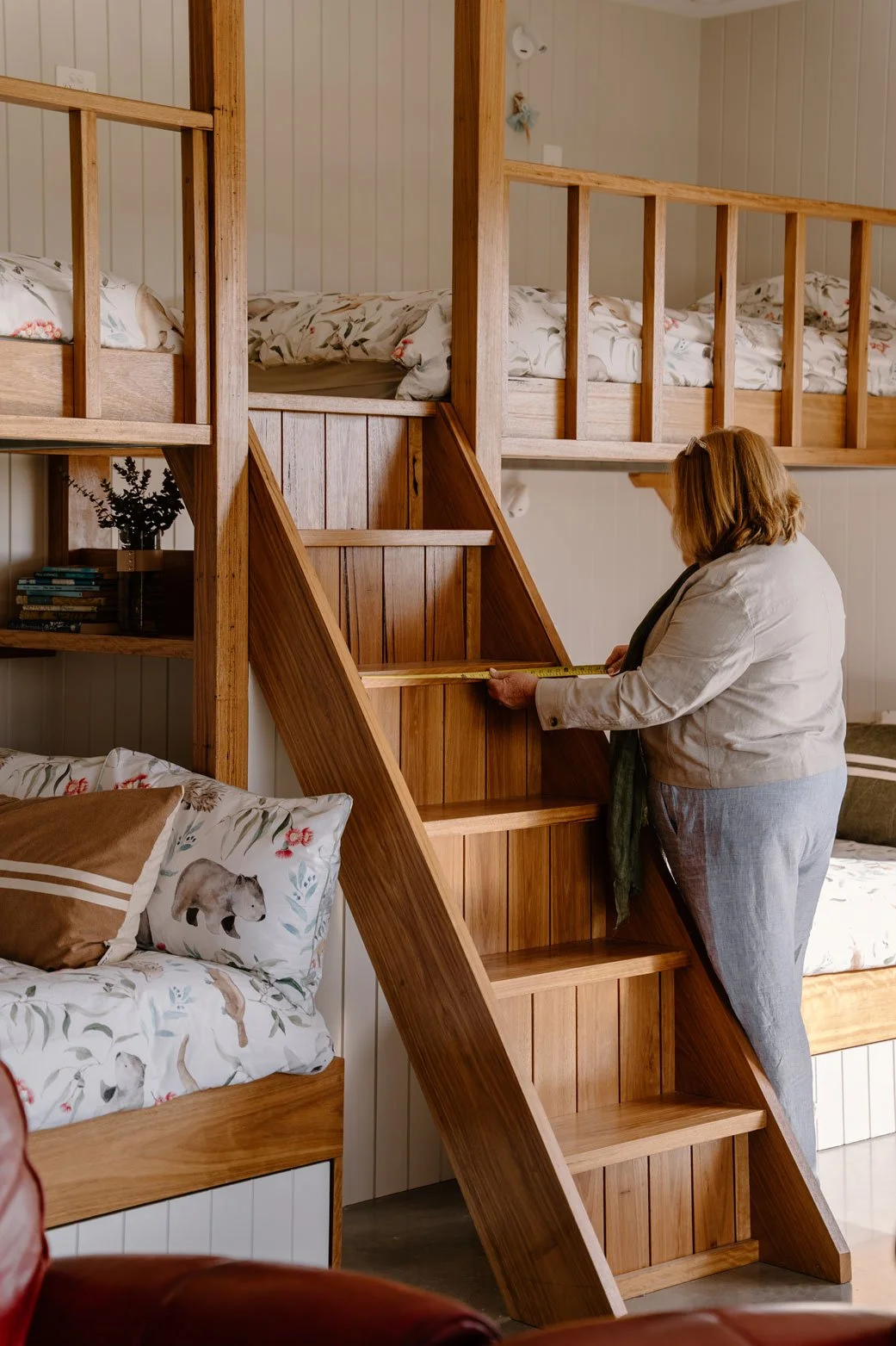 Suziemeasuring a wooden staircase in a bedroom with bunk beds and animal-themed bedding.